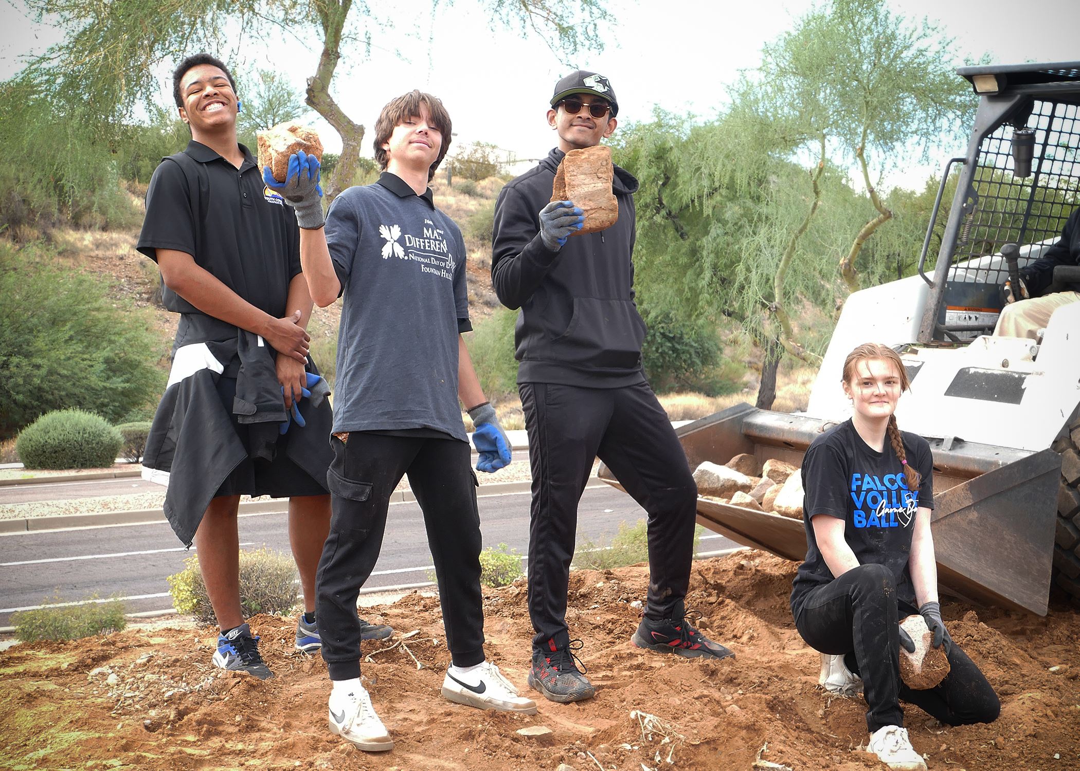Students picking up large rocks as part of Make a Difference Day
